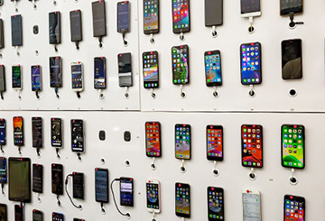 Mehrere Smartphones welche an einer Wand hängen 